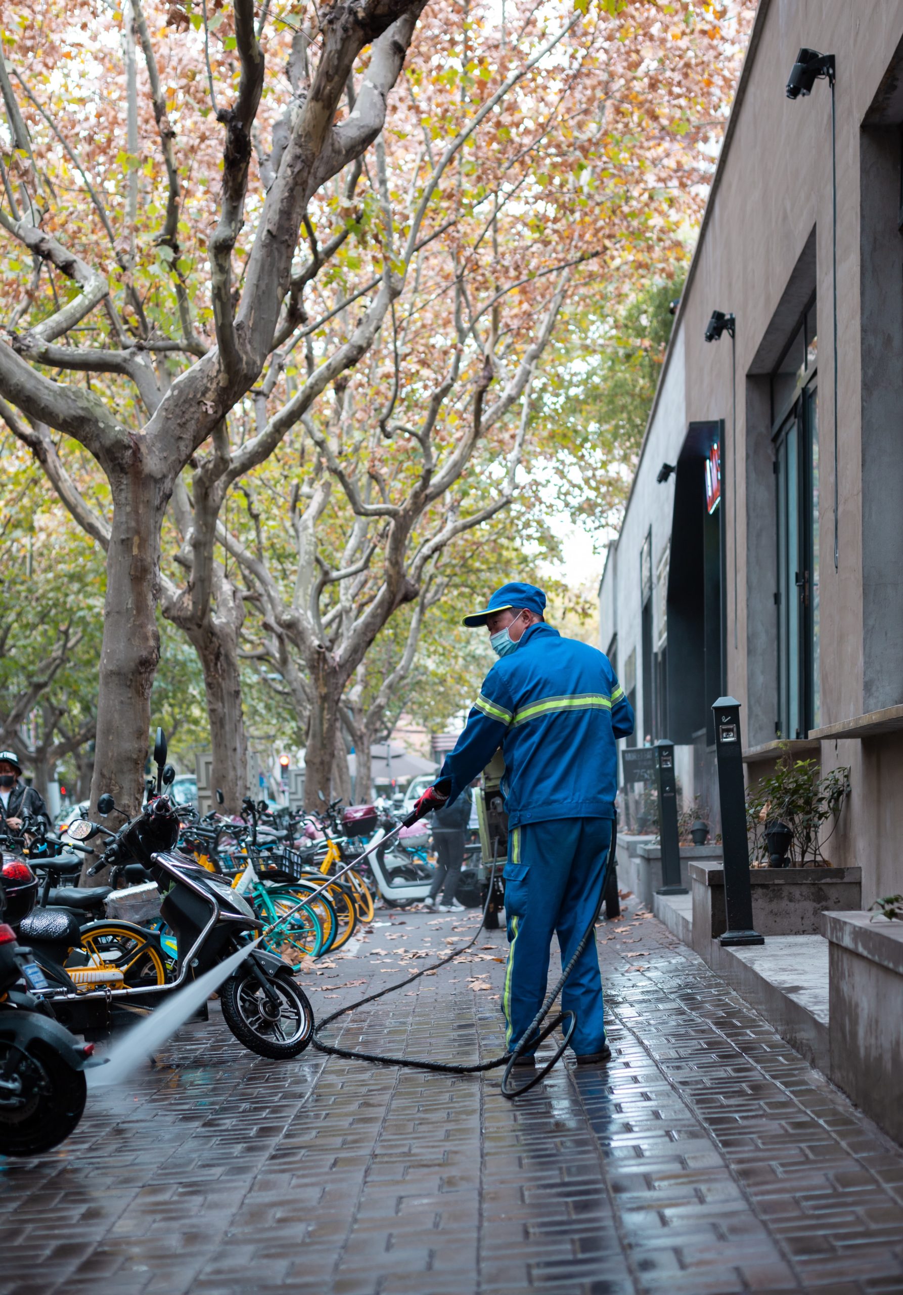 guy cleaning the sidewalk with a power washing machine